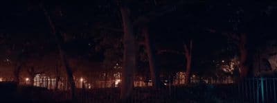 a night scene with a fence and trees