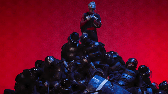a man standing on top of a pile of police officers