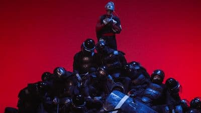 a man standing on top of a pile of police officers