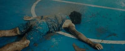 a man laying on a basketball court covered in dirt