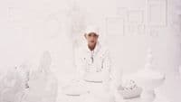 a man sitting at a table in a white room