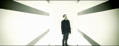 a man standing in front of a white wall