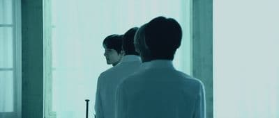 a man standing in front of a mirror in a room