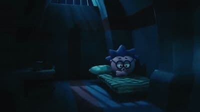 a stuffed animal sitting on top of a bed in a dark room