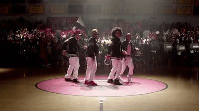 a group of people standing on top of a pink circle
