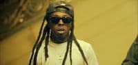 a man with dreadlocks wearing a hat and sunglasses