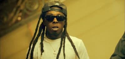 a man with dreadlocks wearing a hat and sunglasses