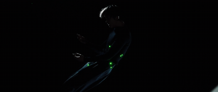 a man in a dark room holding a cell phone