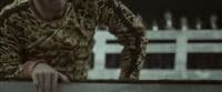 a man in a leopard print shirt leaning on a wall