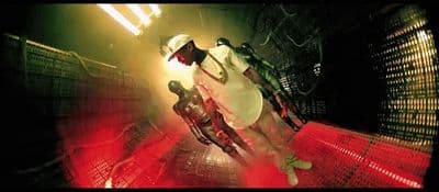 a man in a white shirt and red pants standing in a tunnel