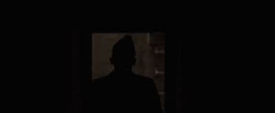 a silhouette of a man in a dark room