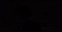 a man in a suit and tie standing in the dark