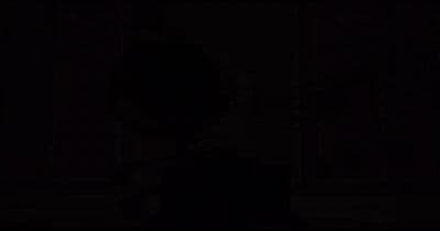 a man in a suit and tie standing in the dark