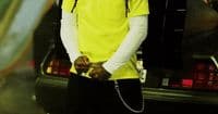 a man in a yellow shirt standing next to a car