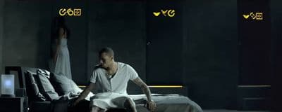 a man sitting on a bed next to a woman