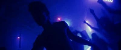 a woman standing in front of a blue light