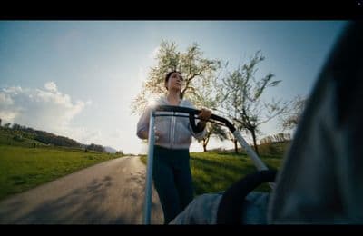 a woman holding a steering wheel while walking down a road