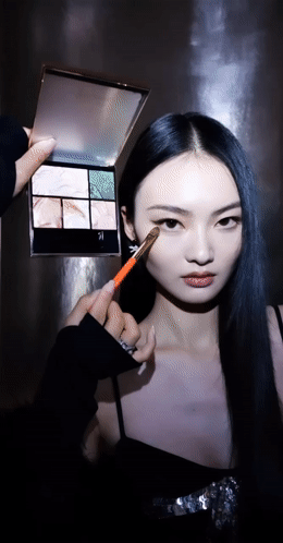 a woman with long black hair holding a brush