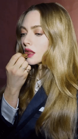 a woman with long blonde hair brushing her teeth