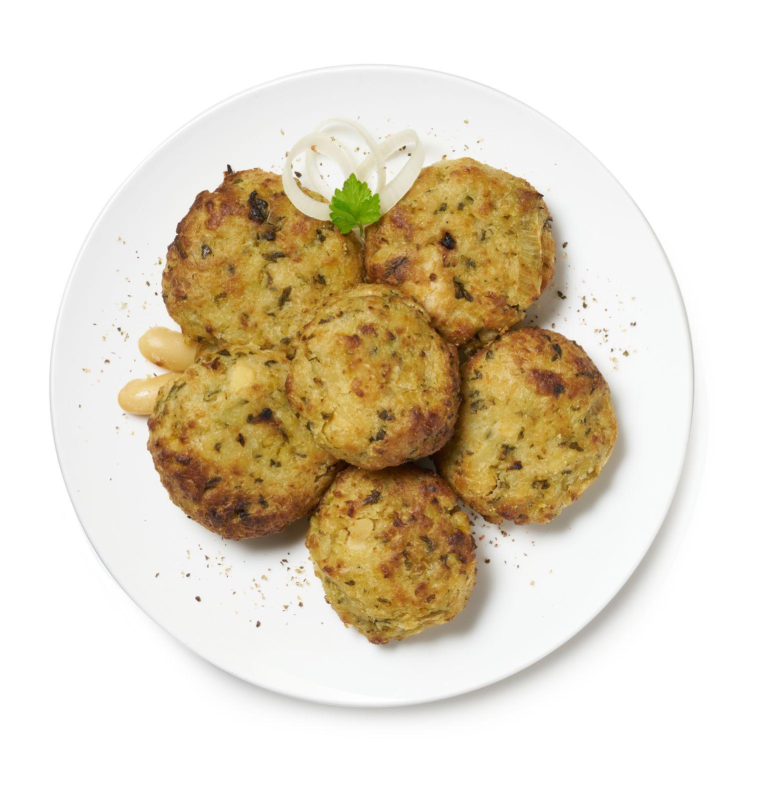 a white plate topped with crab cakes and onions