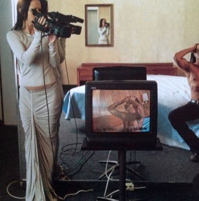 a woman taking a picture of a man with a camera