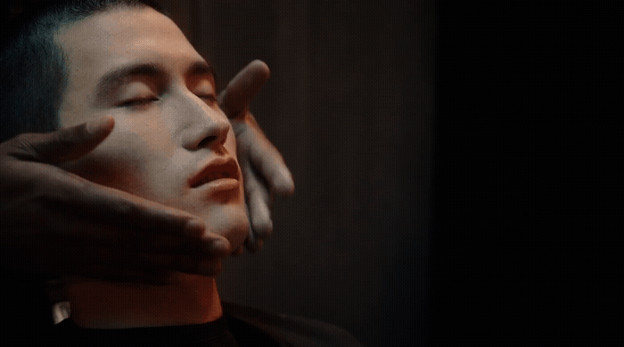 a man holding his hand up to his face
