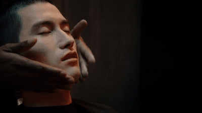 a man holding his hand up to his face