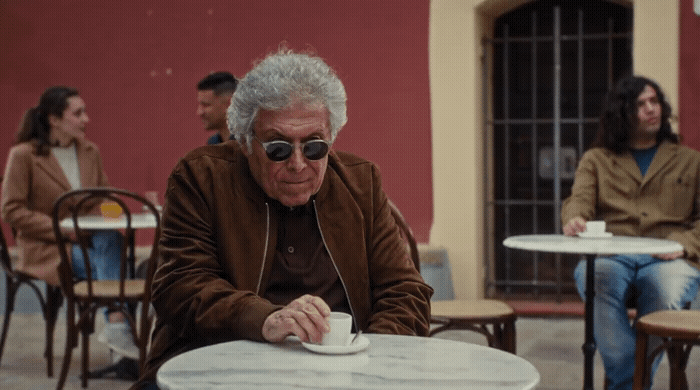 a man sitting at a table with a cup of coffee