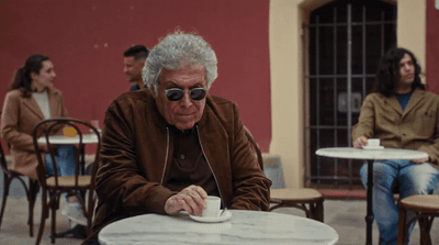 a man sitting at a table with a cup of coffee