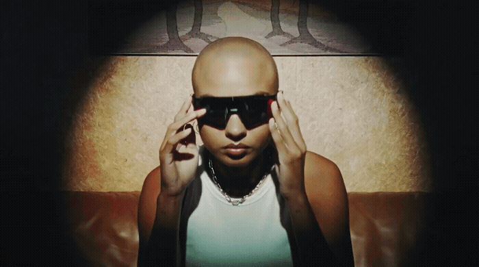 a woman with a bald head wearing sunglasses