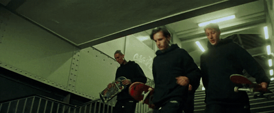 a group of men carrying skateboards down a flight of stairs