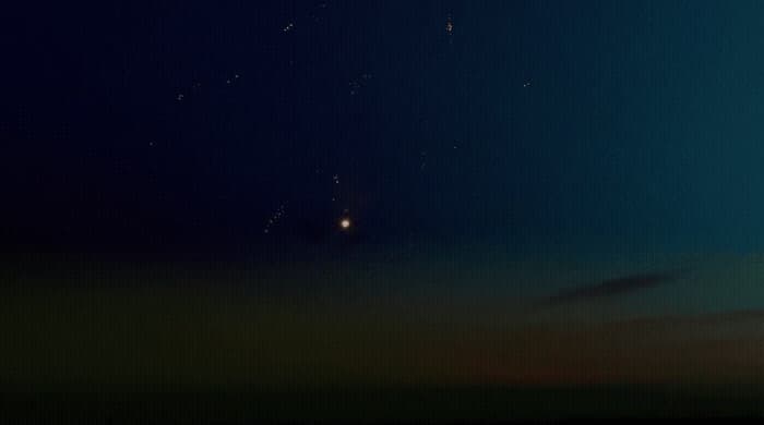 a group of people flying kites in the night sky