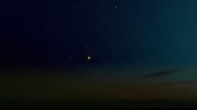 a group of people flying kites in the night sky