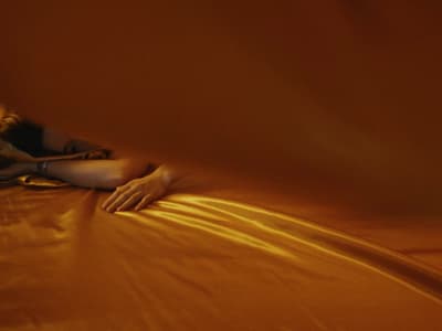 a woman laying on top of a bed under a blanket