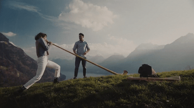 a couple of people standing on top of a lush green hillside