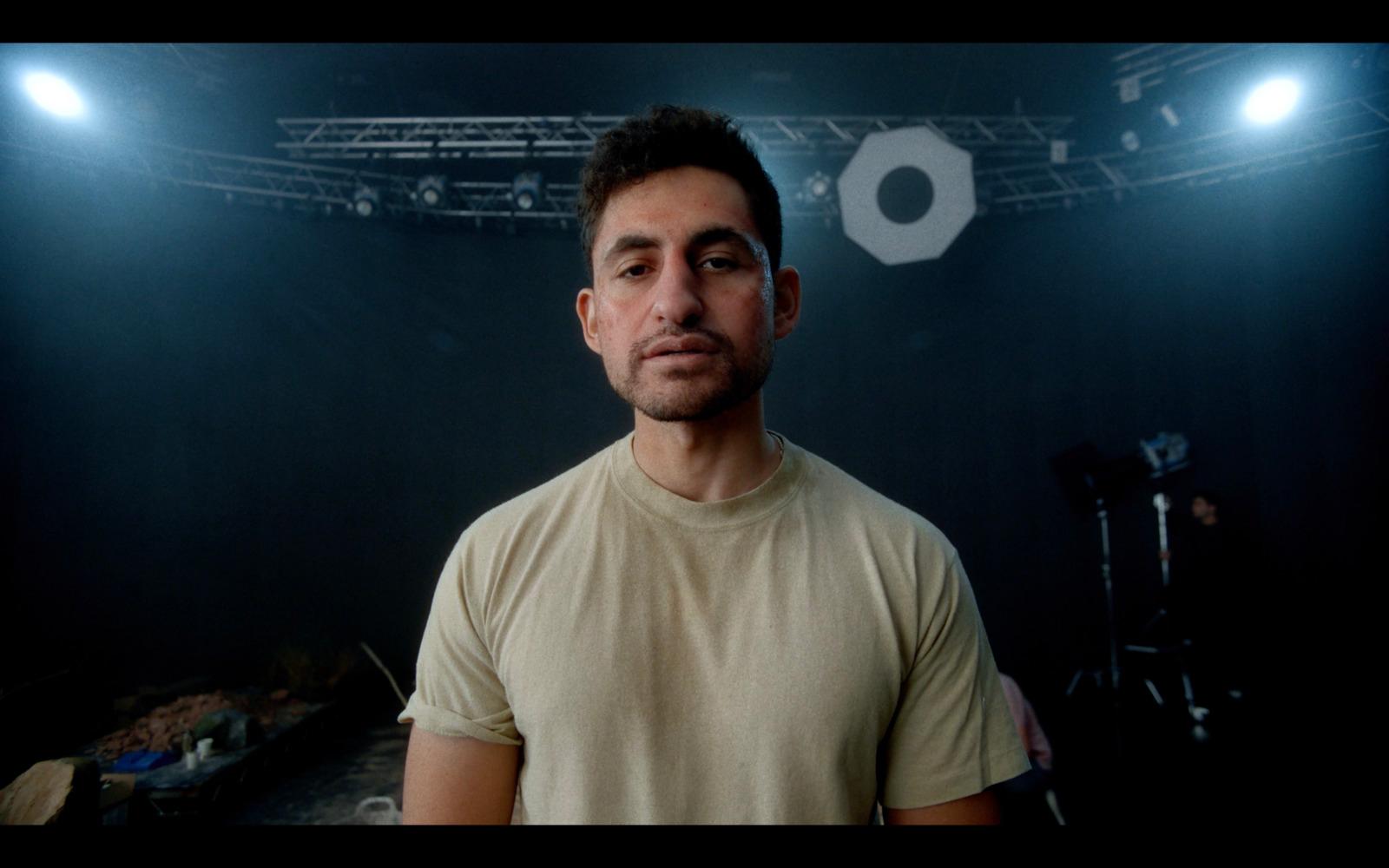 a man standing in front of a camera in a dark room