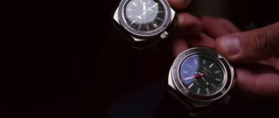 a person holding two watches in their hands