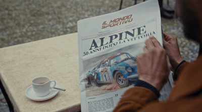 a man sitting at a table reading a newspaper