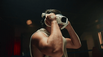 a man in a tank top holding a camera up to his face