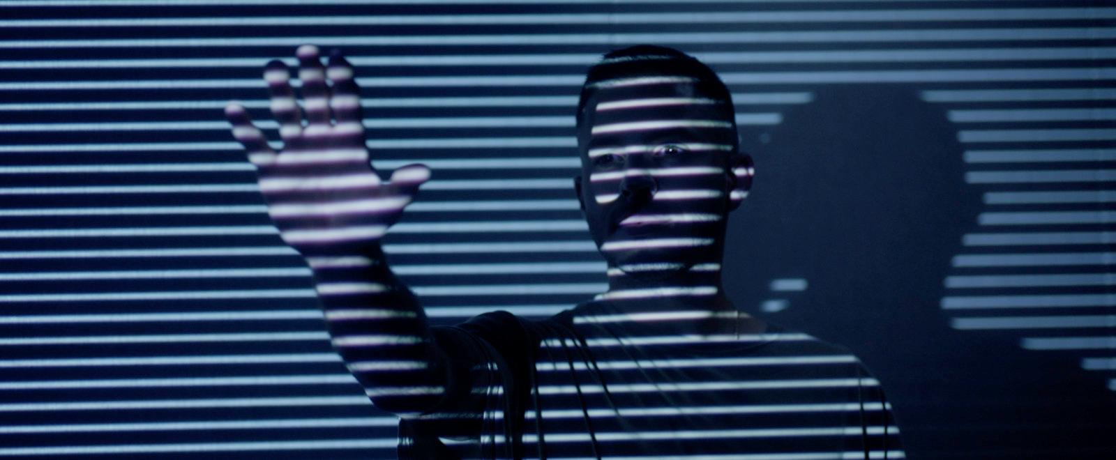 a person standing in front of a window with a shadow on it