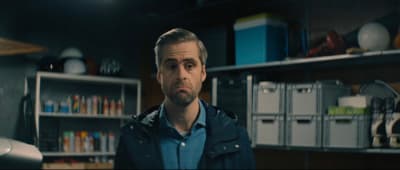 a man standing in front of a book shelf