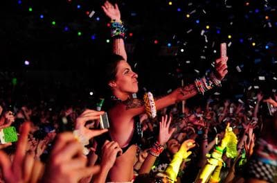 a crowd of people at a concert with confetti thrown in the air