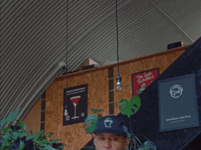 a man wearing a hat standing in front of a wall