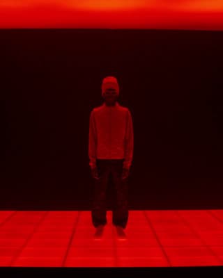 a man standing in front of a red background