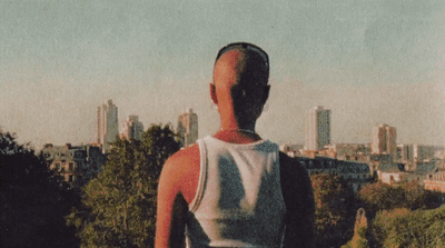 a person standing on a hill with a city in the background
