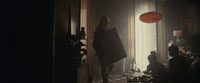 a woman in a dark room with a red lantern