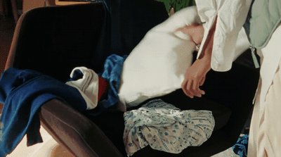 a person laying in a chair with a bunch of clothes on it