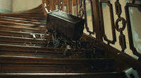 a piece of luggage sitting on top of a wooden staircase