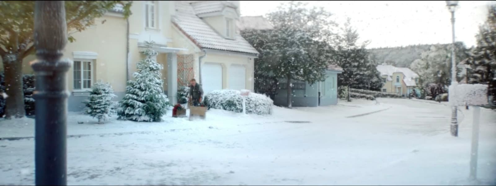 a snow covered street with houses and trees