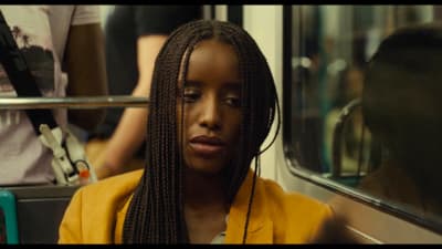 a woman with braids sitting on a bus
